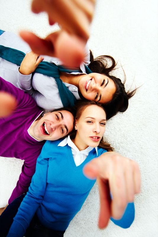Ragazze e ragazzi sorridenti sdraiati a terra